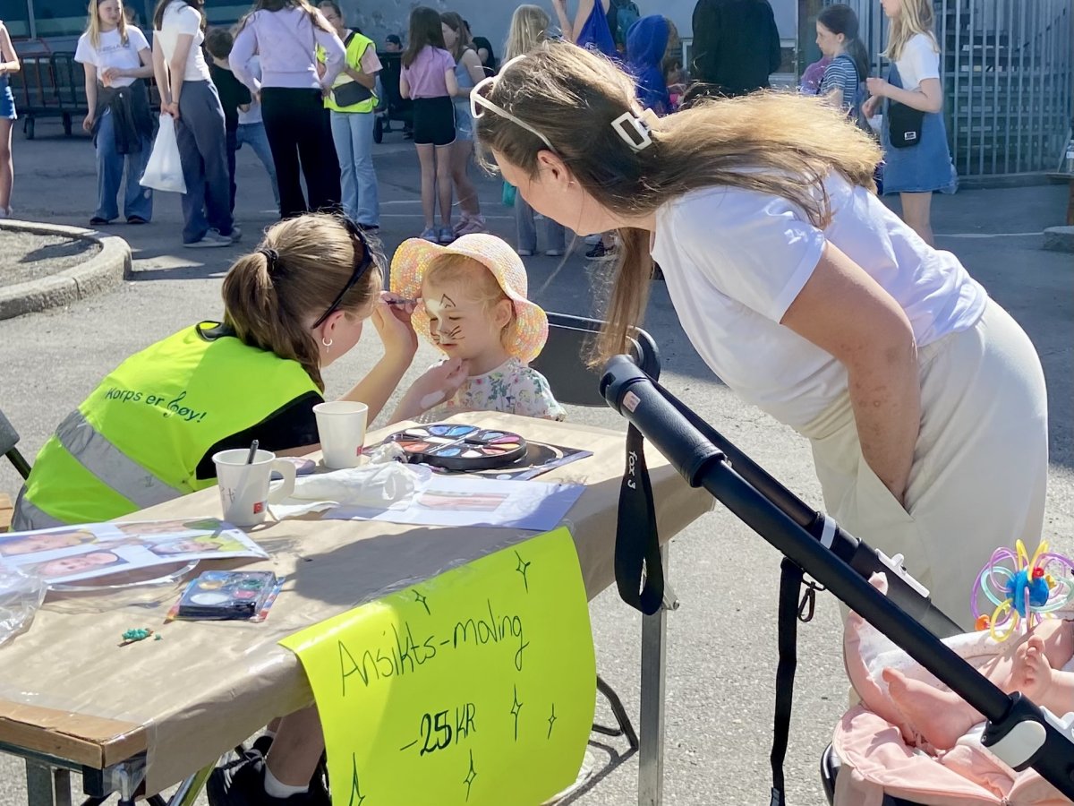 Lita jente som får ansiktsmaling på Kjelsås skoles musikkorps' loppemarked. 